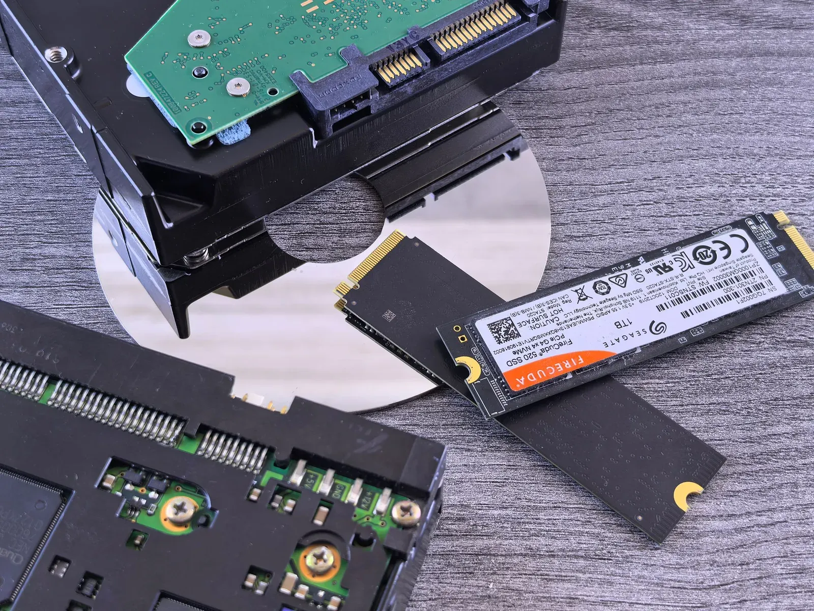 An NVMe SSD beside mechanical hard drives and an optical disc